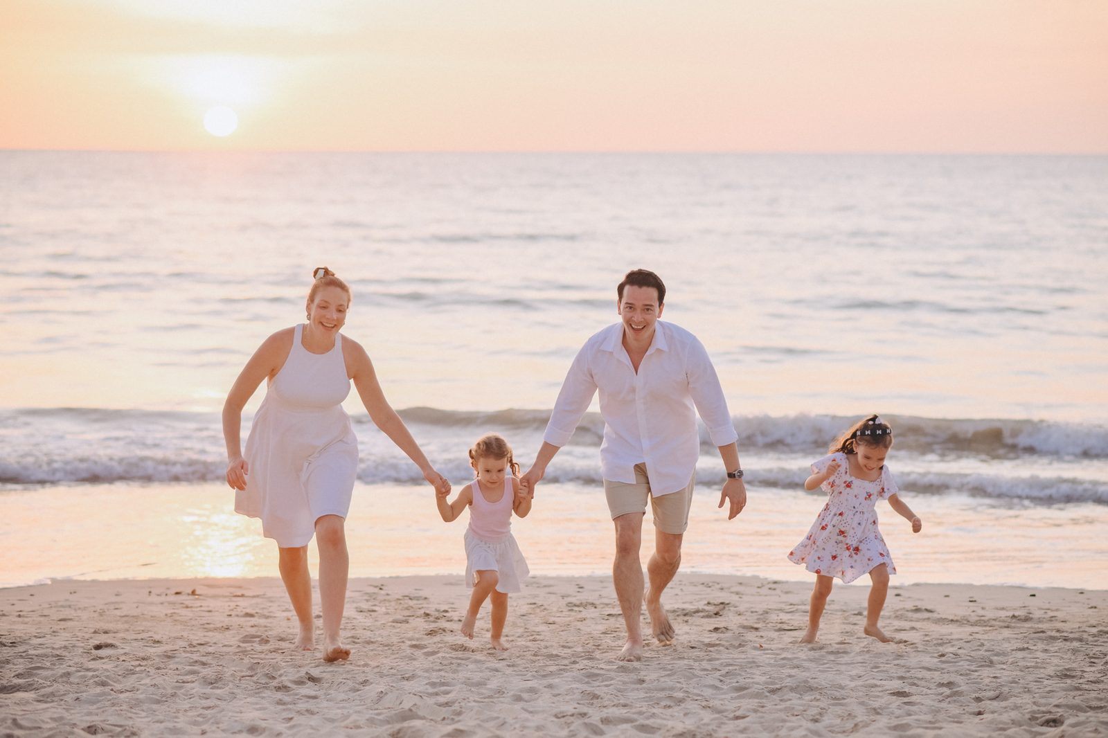 Family walking along the beach at sunset in Khao Lak